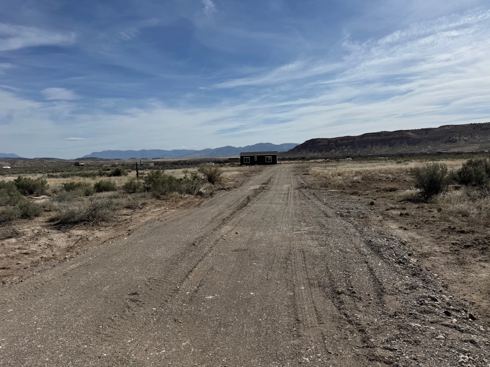 View of gravel road featuring a mountain view and a view of rural landscapes.