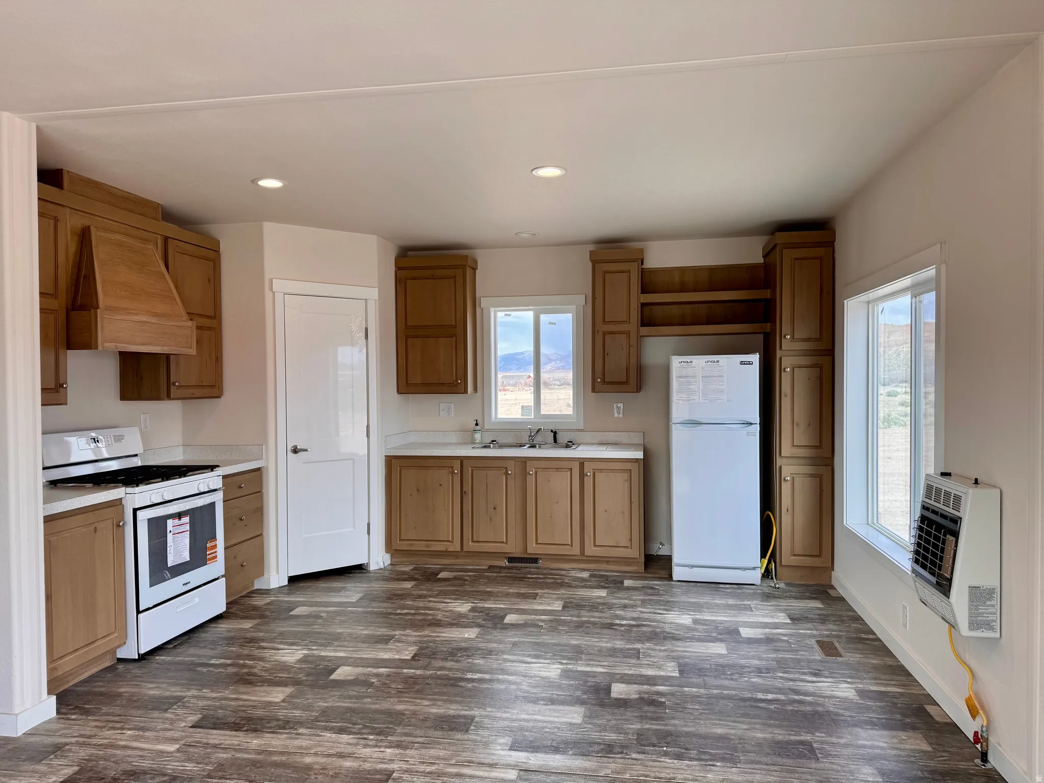 Kitchen with white appliances, light countertops, recessed lighting, dark wood-type flooring