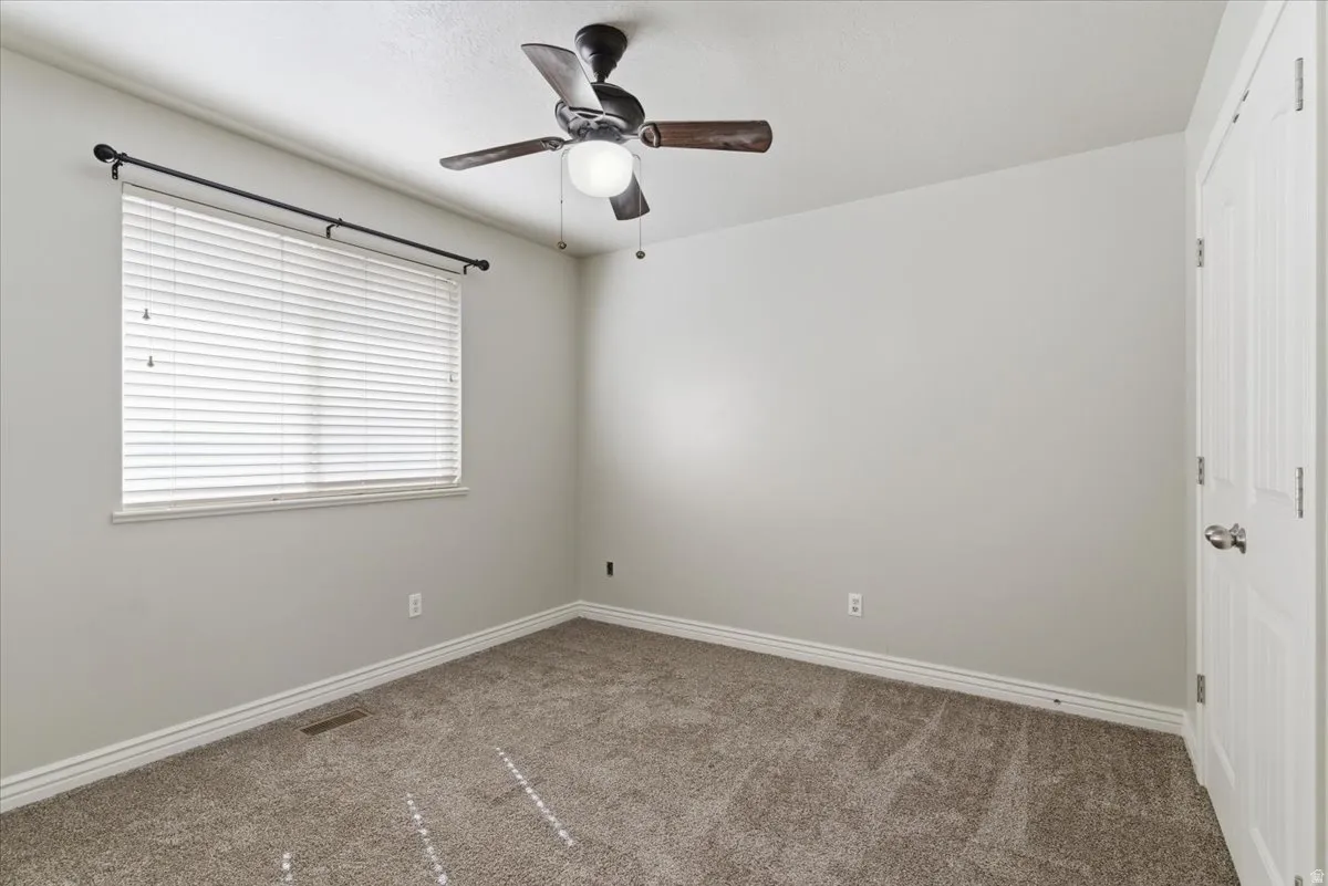 Spare room featuring carpet floors and ceiling fan