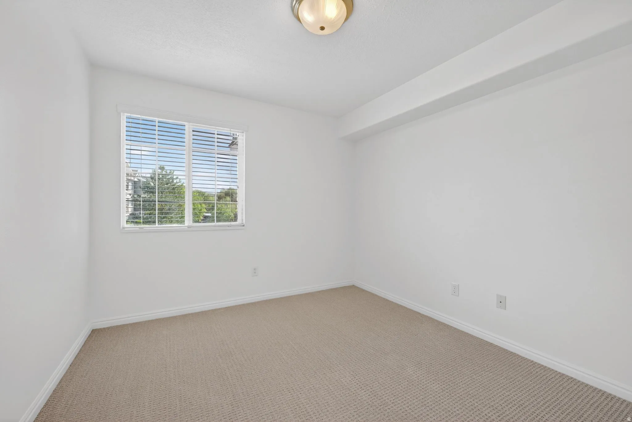 Spare room featuring carpet floors and baseboards
