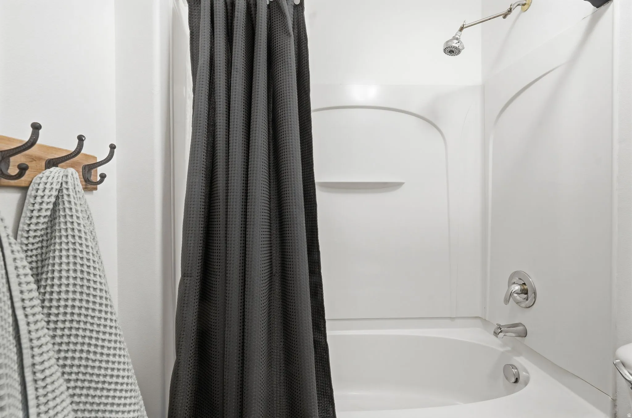 Bathroom with toilet and shower / bath combination with curtain
