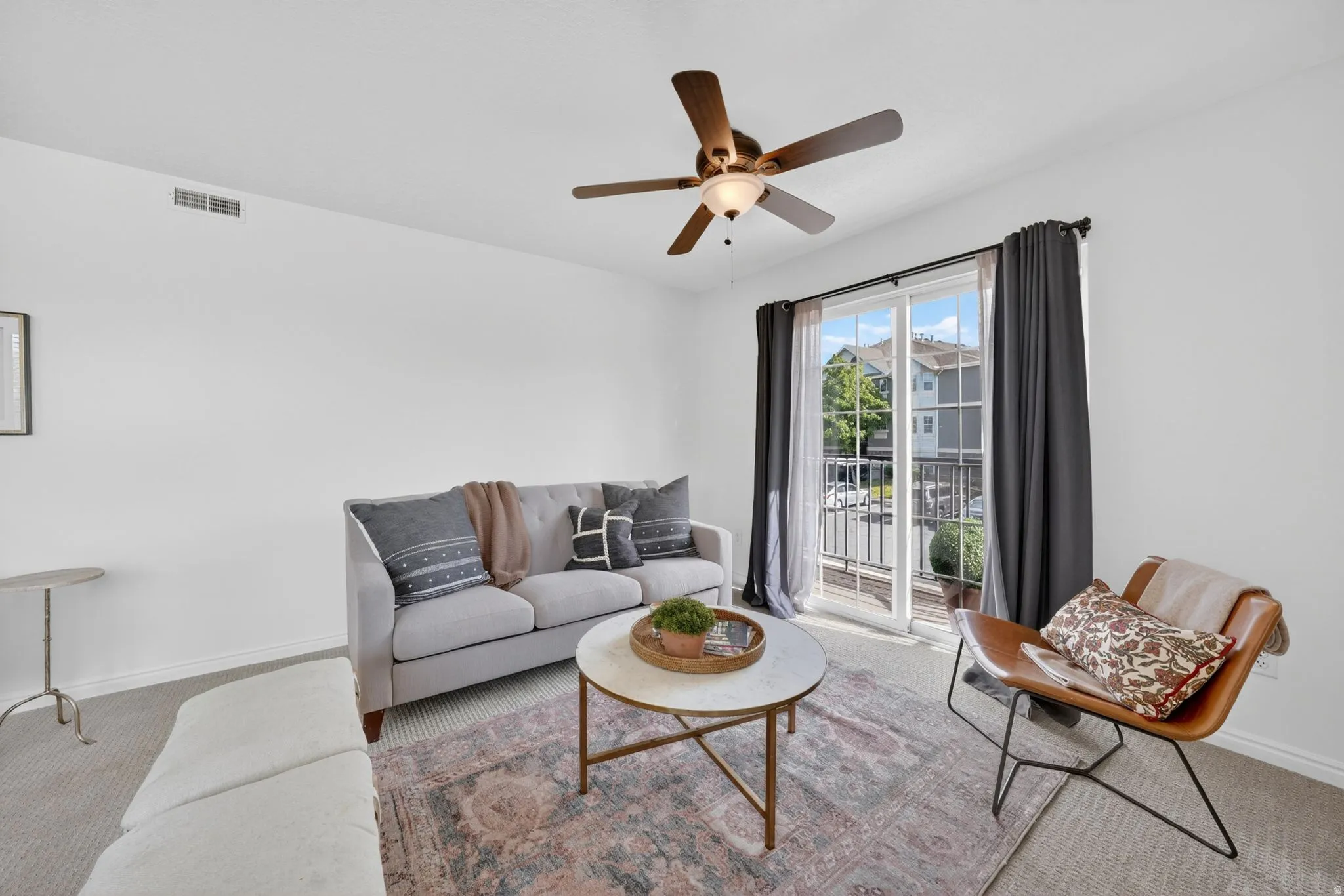 Living room with carpet flooring and ceiling fan