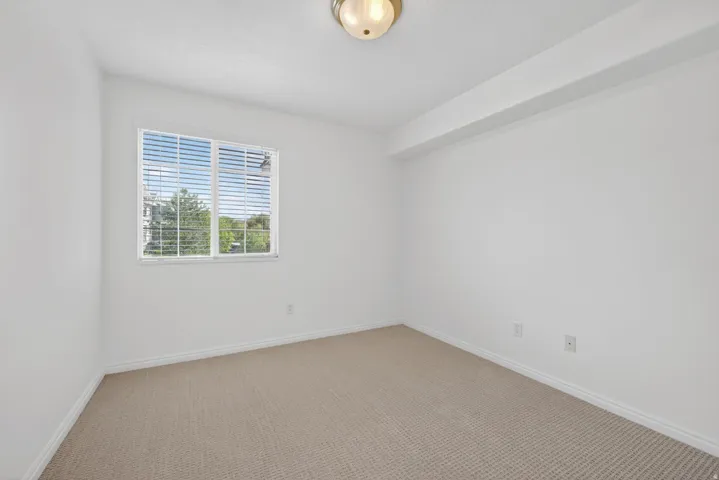 Spare room featuring carpet floors and baseboards