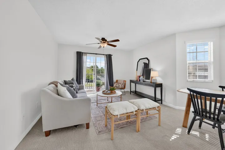 Living area with ceiling fan, carpet, and a textured ceiling