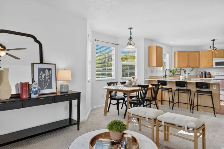 Dining area with light colored carpet and a ceiling fan