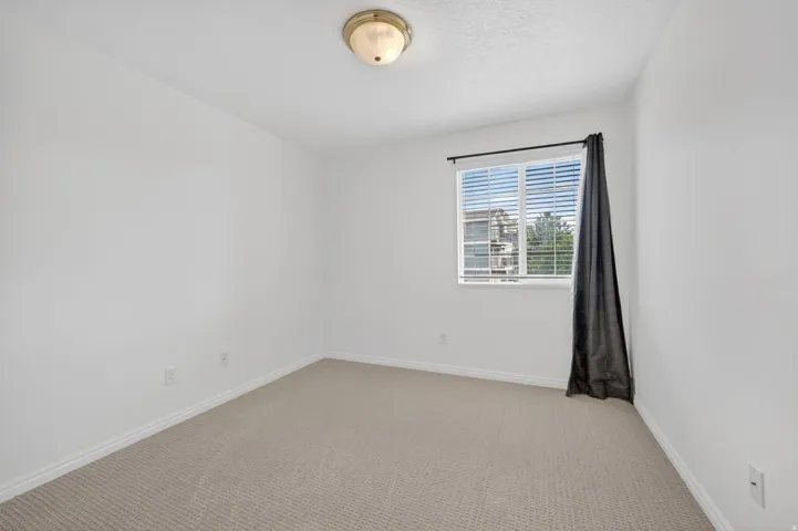 Unfurnished room featuring light colored carpet and baseboards