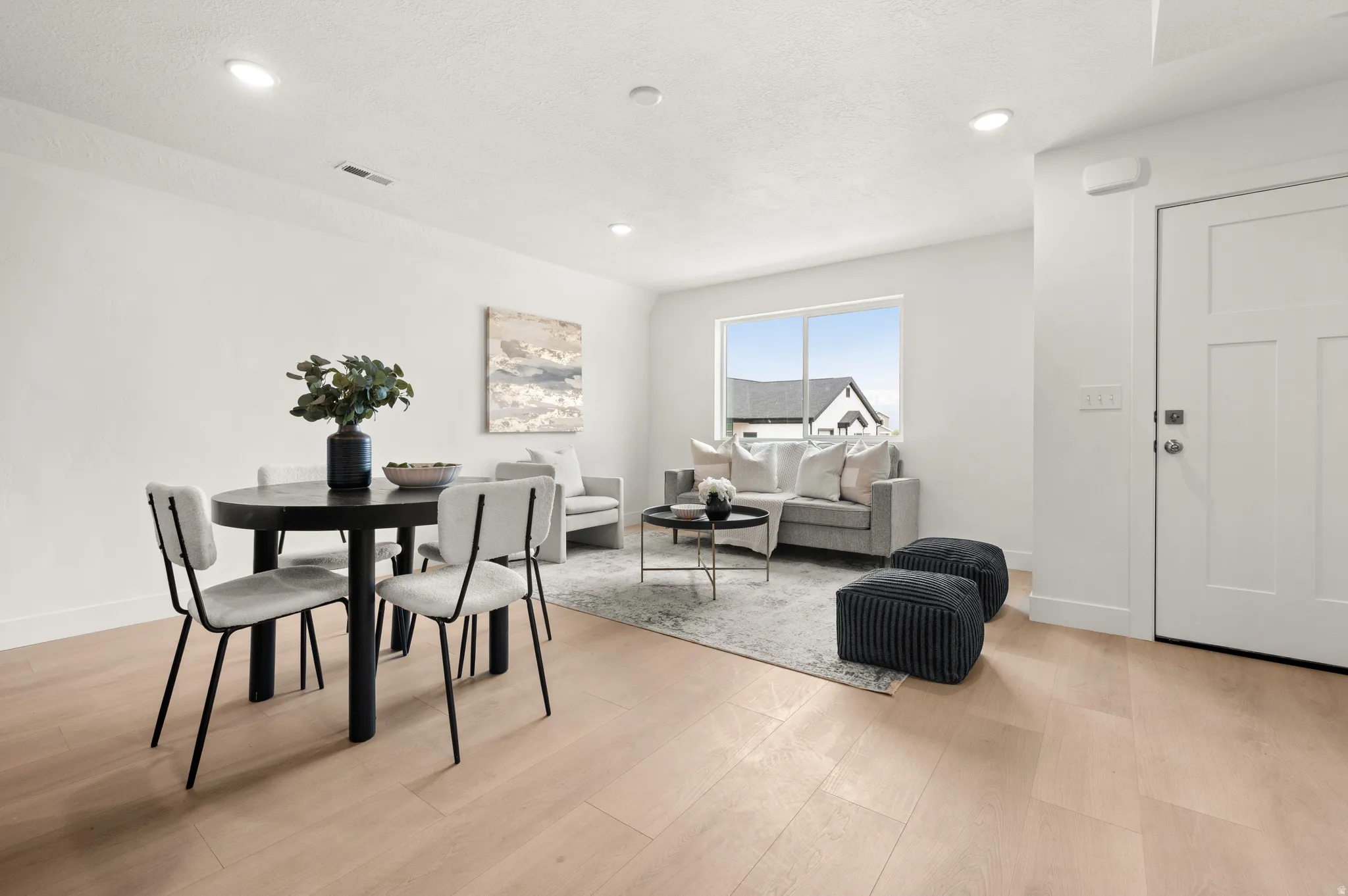Dining room with light wood finished floors and recessed lighting