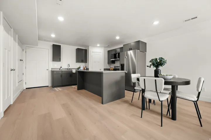 Kitchen with stainless steel appliances, a center island, light wood finished floors, light countertops, and recessed lighting