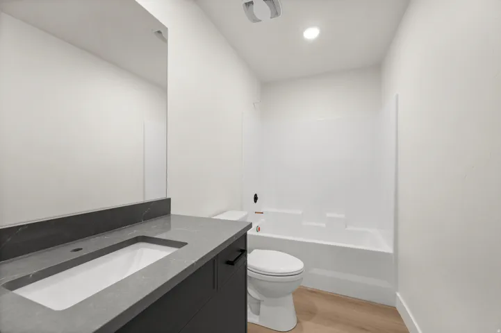 Bathroom featuring vanity, light wood finished floors, and shower / tub combination