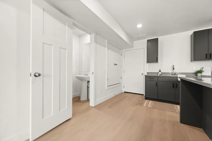 Laundry area featuring light wood-style flooring and recessed lighting