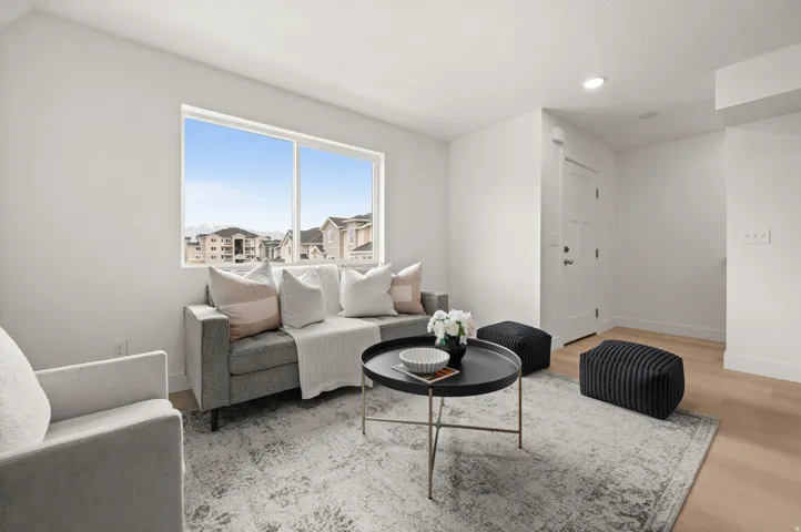 Living area featuring light wood-style flooring, recessed lighting, and a residential view