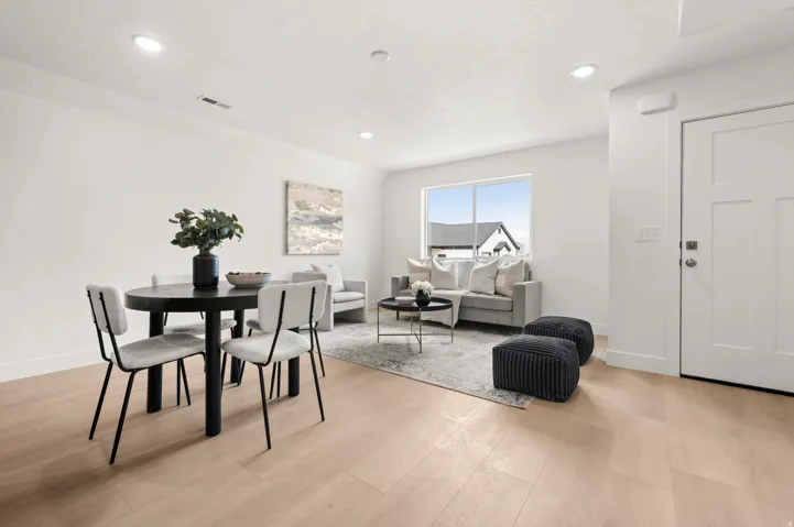 Dining room with light wood finished floors and recessed lighting