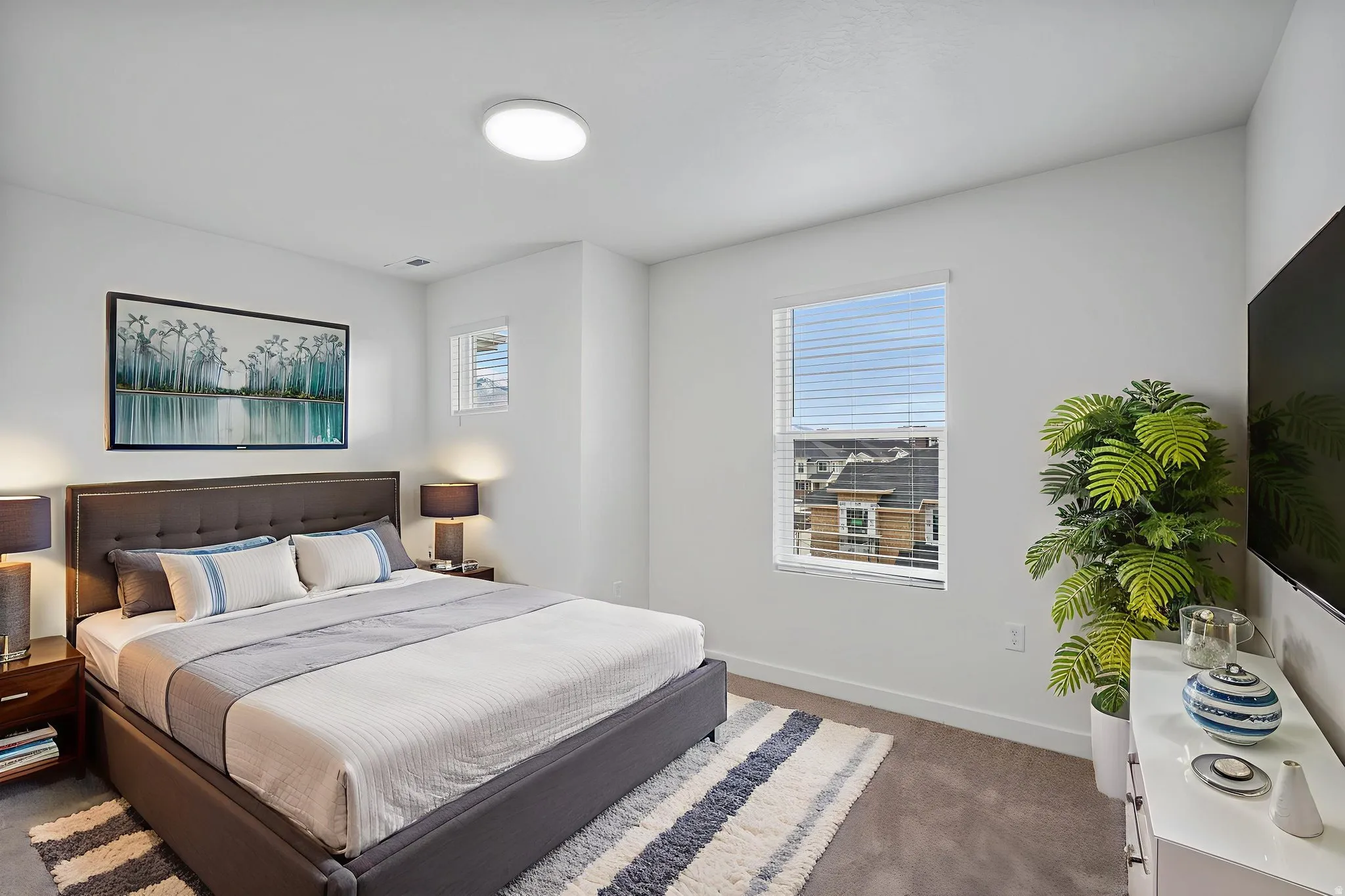 Bedroom with dark carpet and multiple windows
