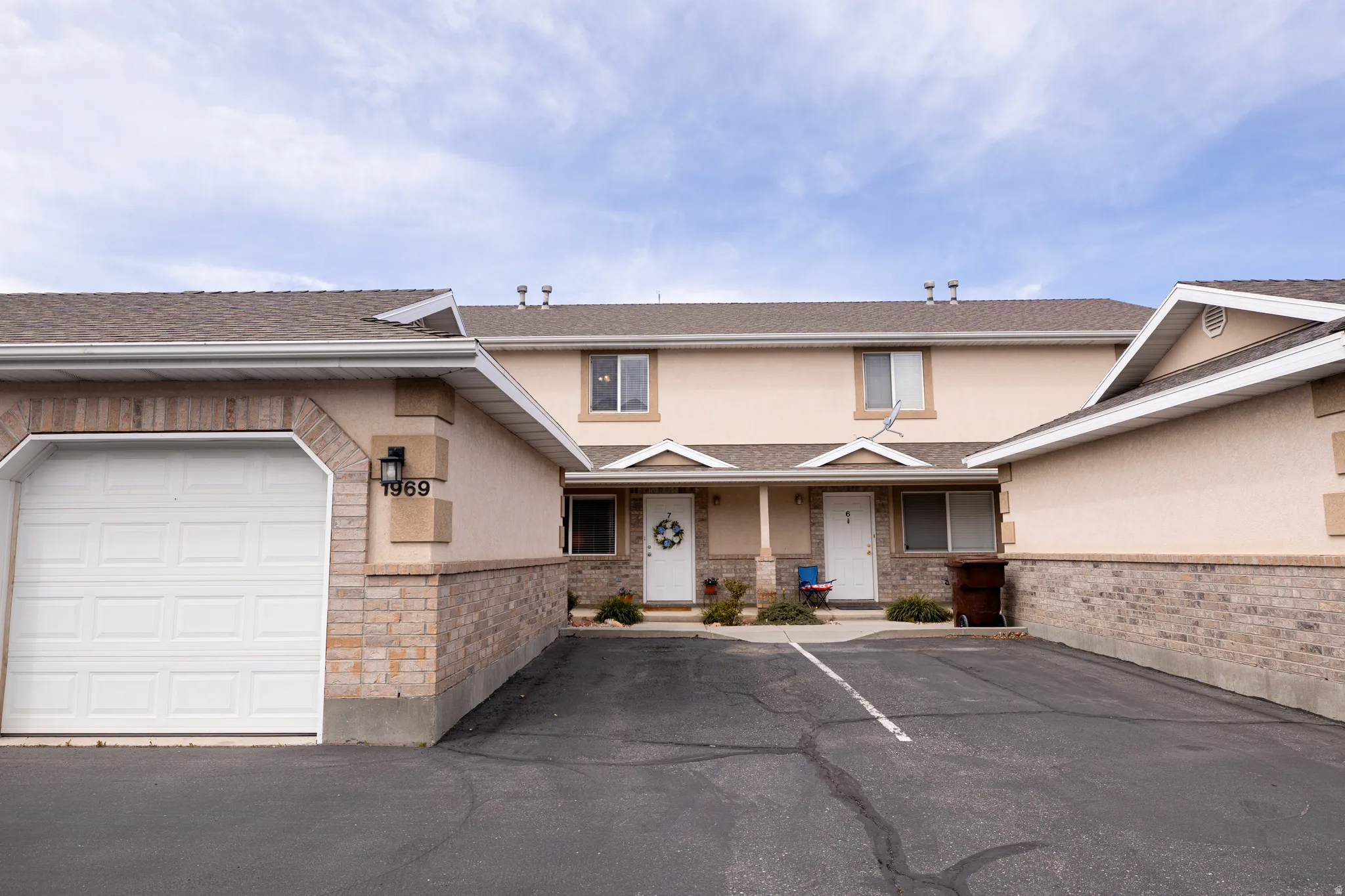 View of front of house with roof with shingles, stucco siding, a porch, and stone siding
