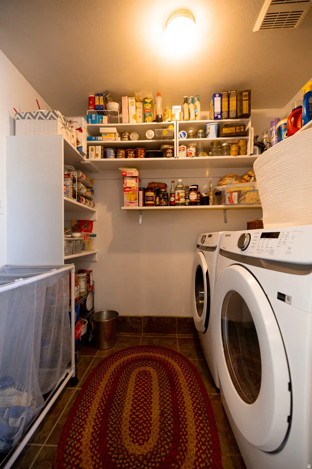 Laundry area featuring washer and clothes dryer and dark tile patterned flooring