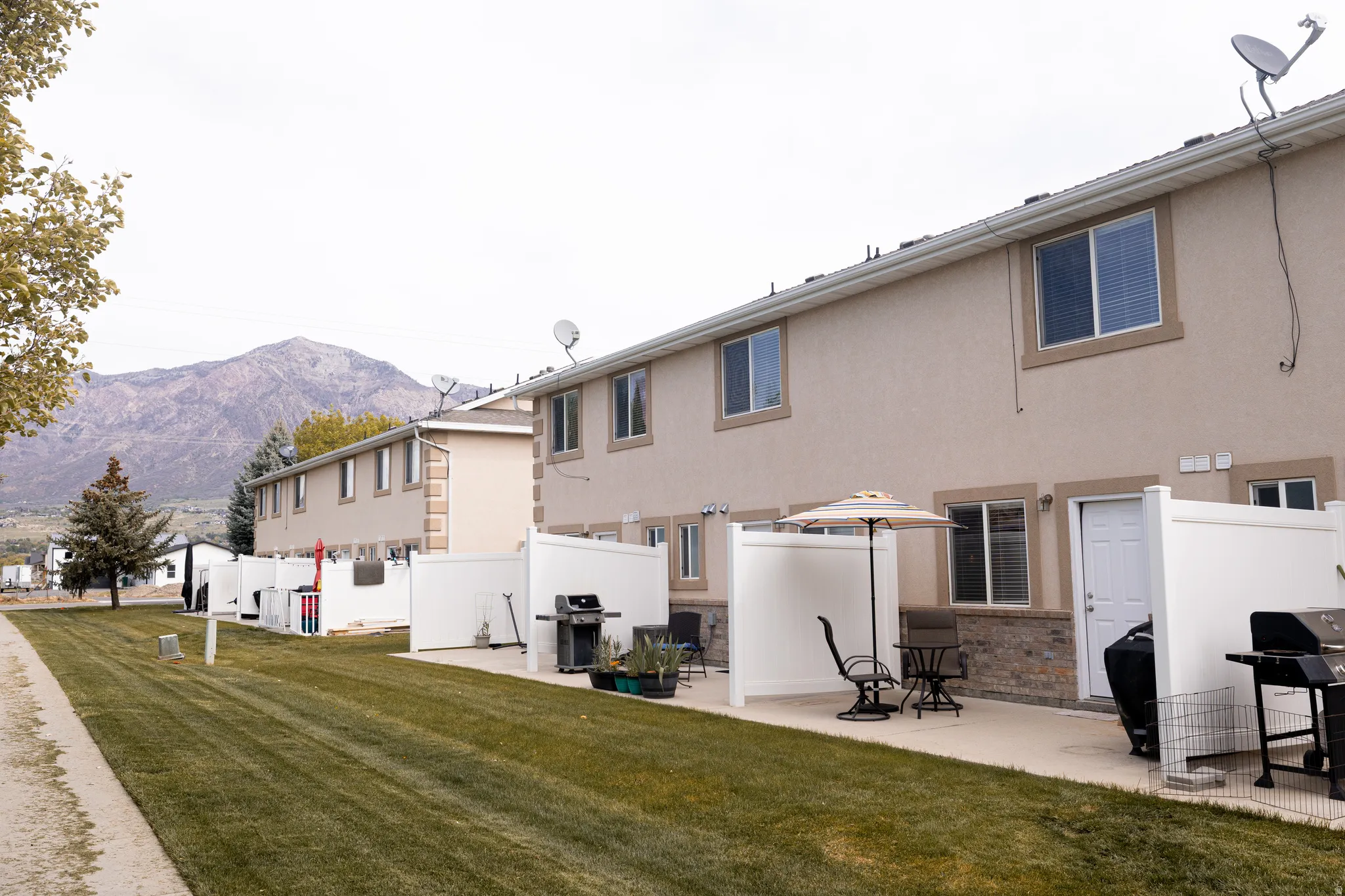 Rear view of property featuring stucco siding, a patio area, and a mountain view