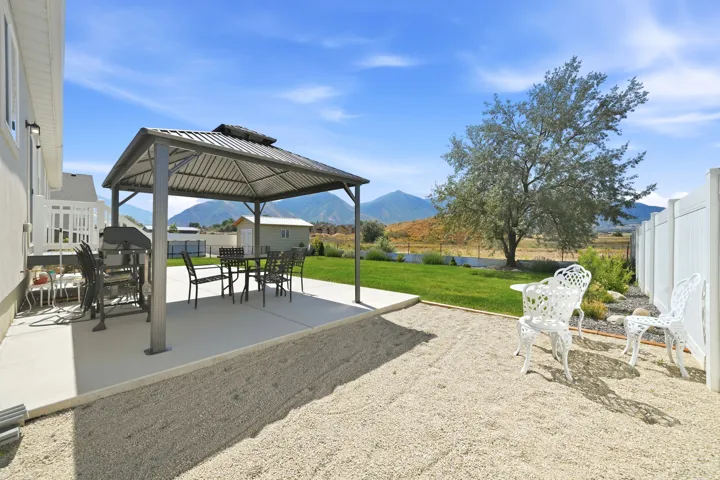 Expansive backyard featuring a concrete patio with a built-in gazebo