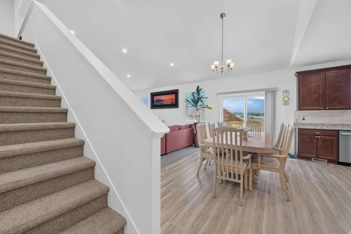 Open-concept living space featuring wood-finish flooring, recessed lighting, and a sliding glass door