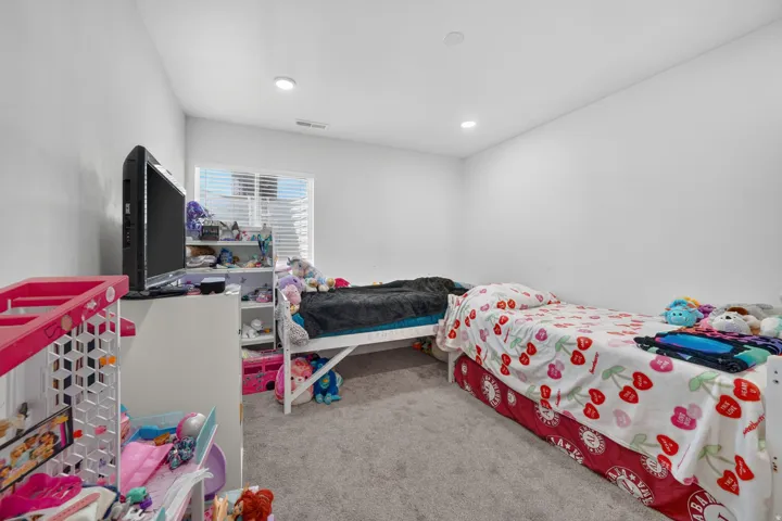 Carpeted room with a window featuring blinds, recessed lighting, and white walls