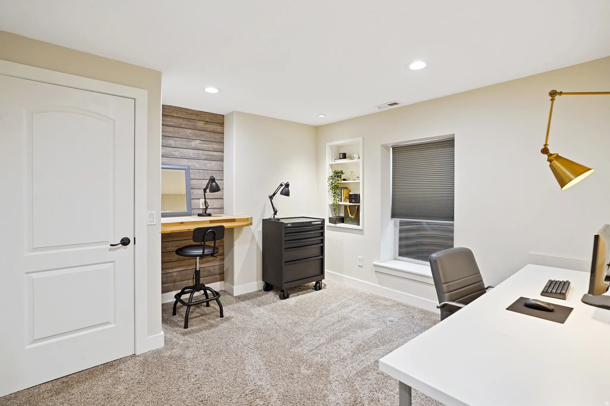 Office with light colored carpet, built in shelves, and recessed lighting