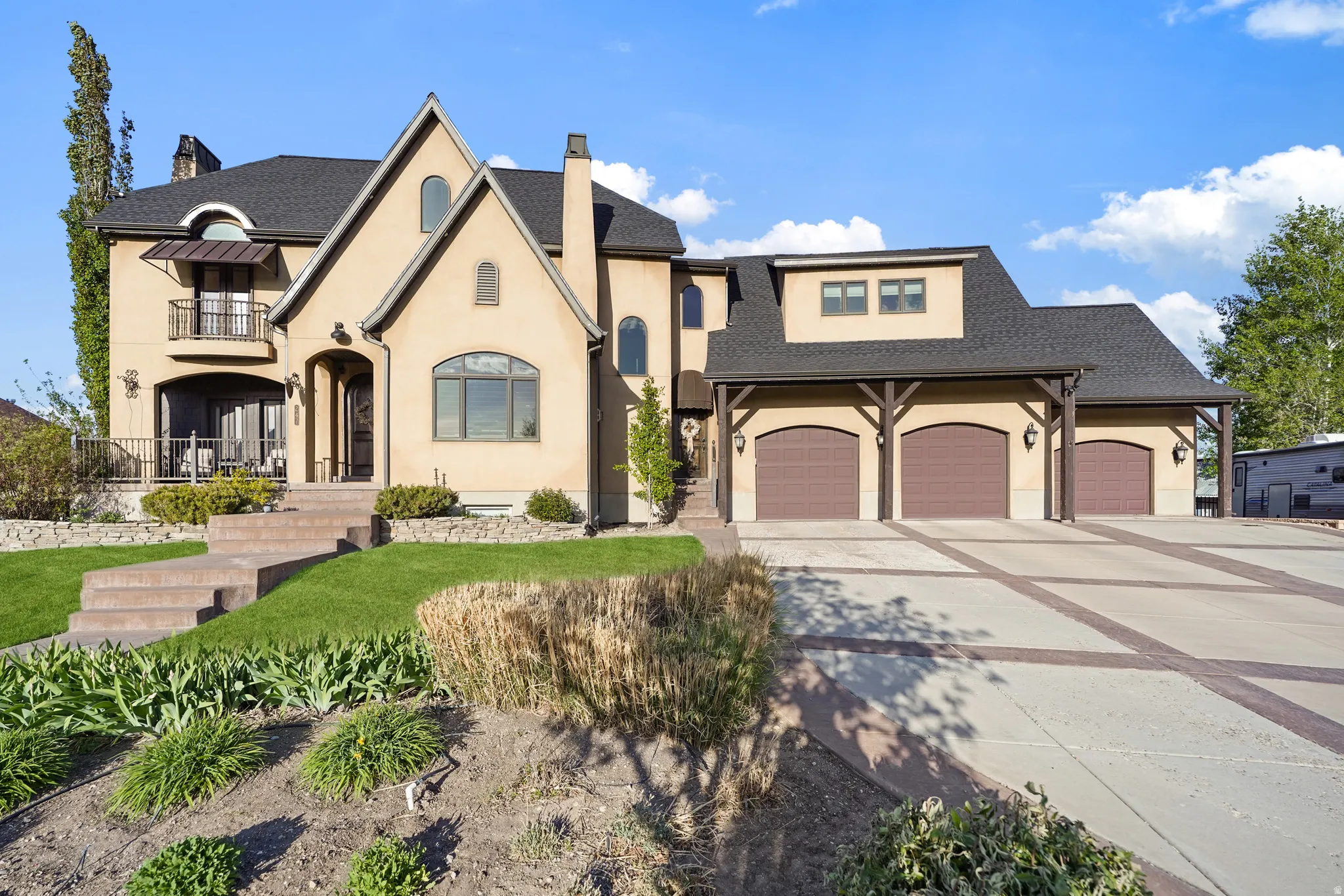French country style house with a chimney, concrete driveway, stucco siding, a garage, and roof with shingles
