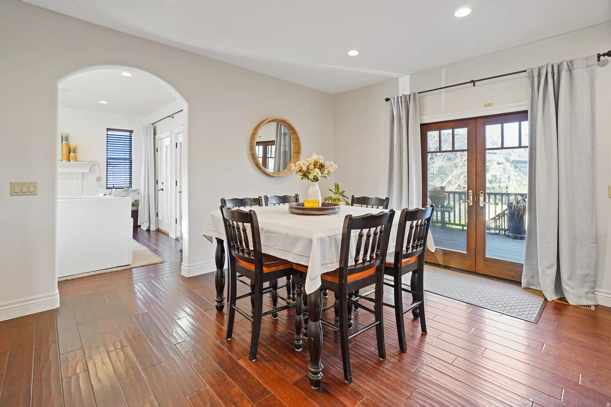 Dining room with french doors, arched walkways, dark wood-style floors, recessed lighting, and healthy amount of natural light