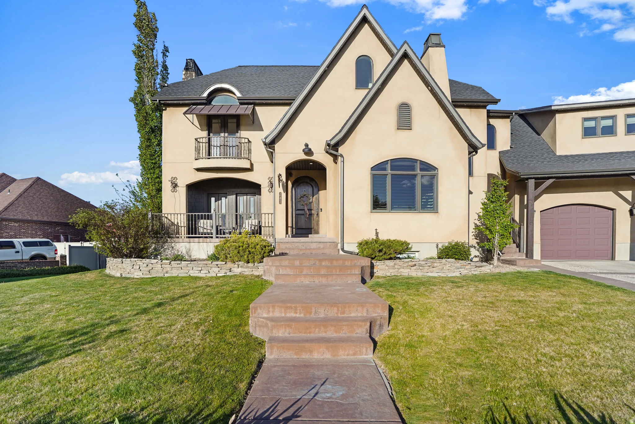French provincial home featuring a chimney, stucco siding, and a front yard
