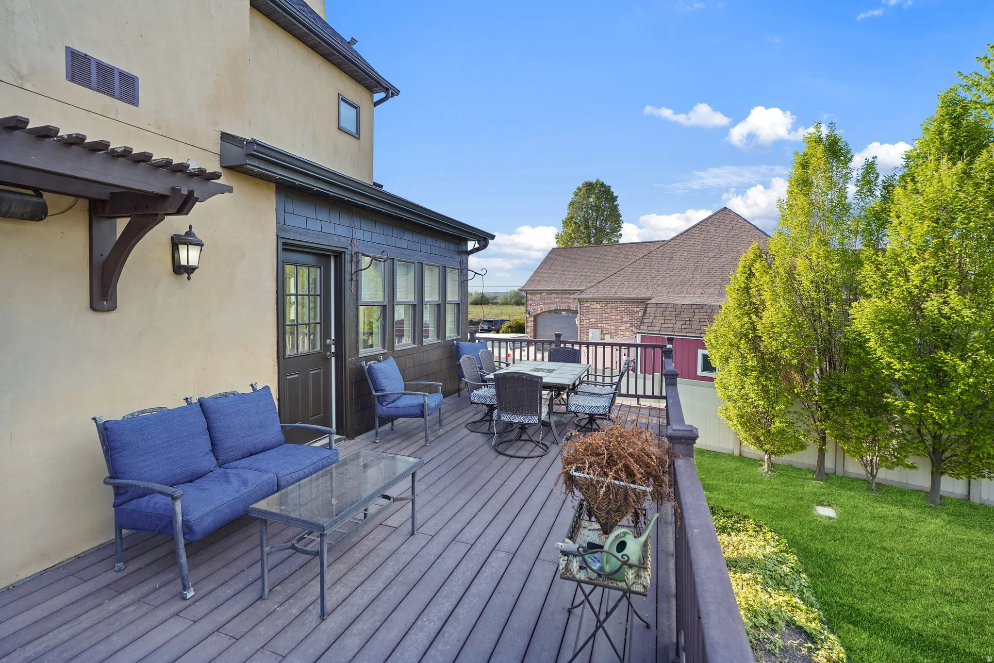 Wooden terrace featuring an outdoor living / dining area and a lawn