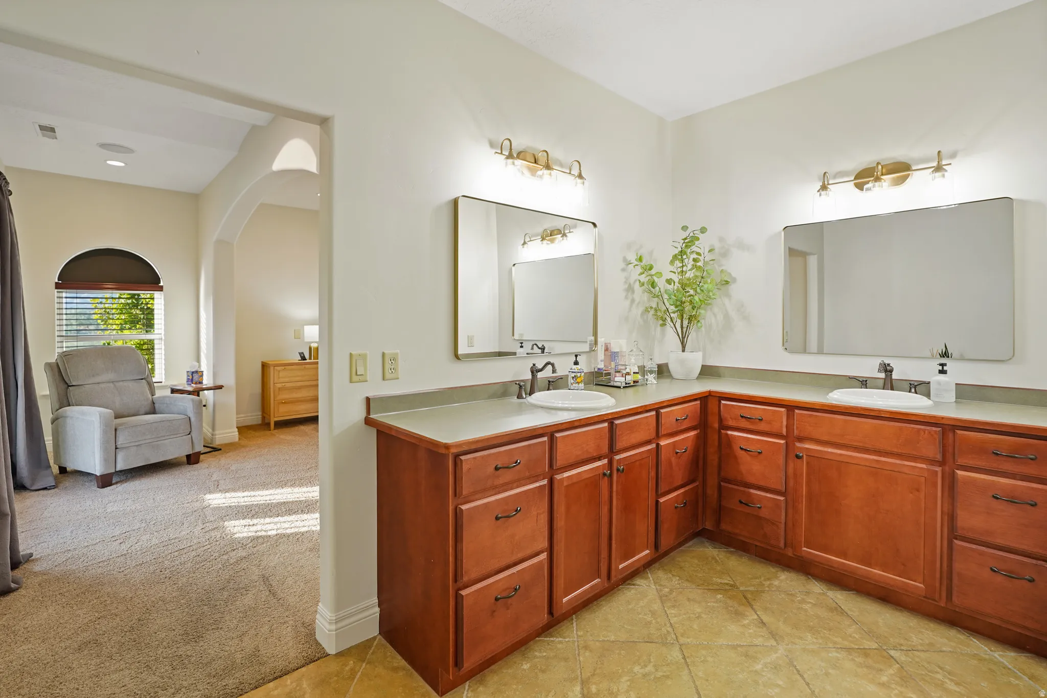 Primary bath with double vanity, light tile patterned floors, and connected bathroom