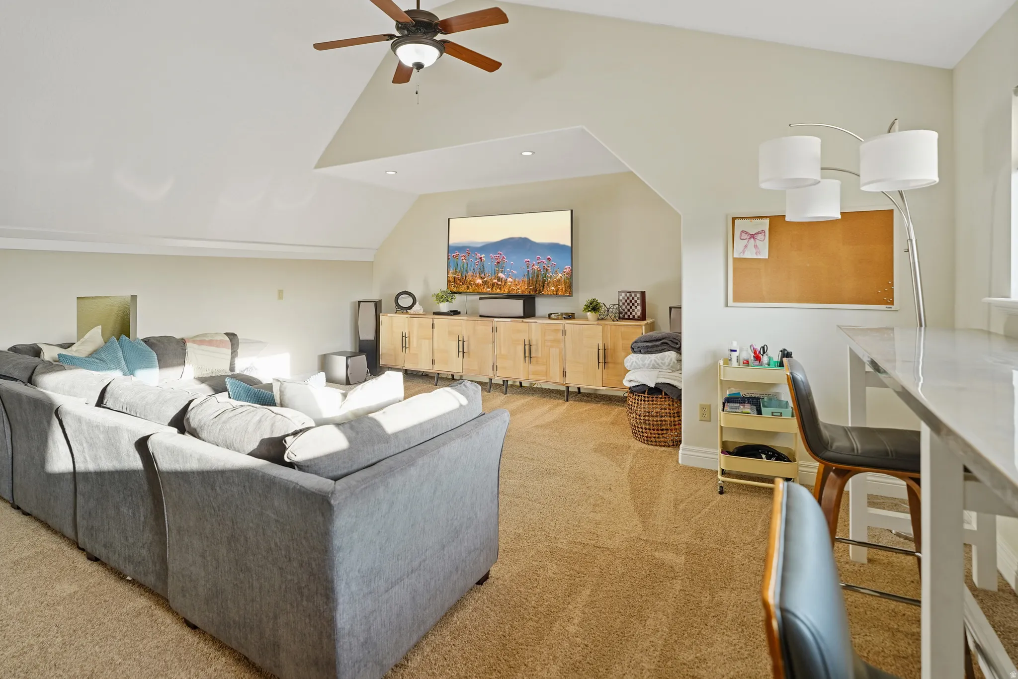Living area with light colored carpet and a ceiling fan