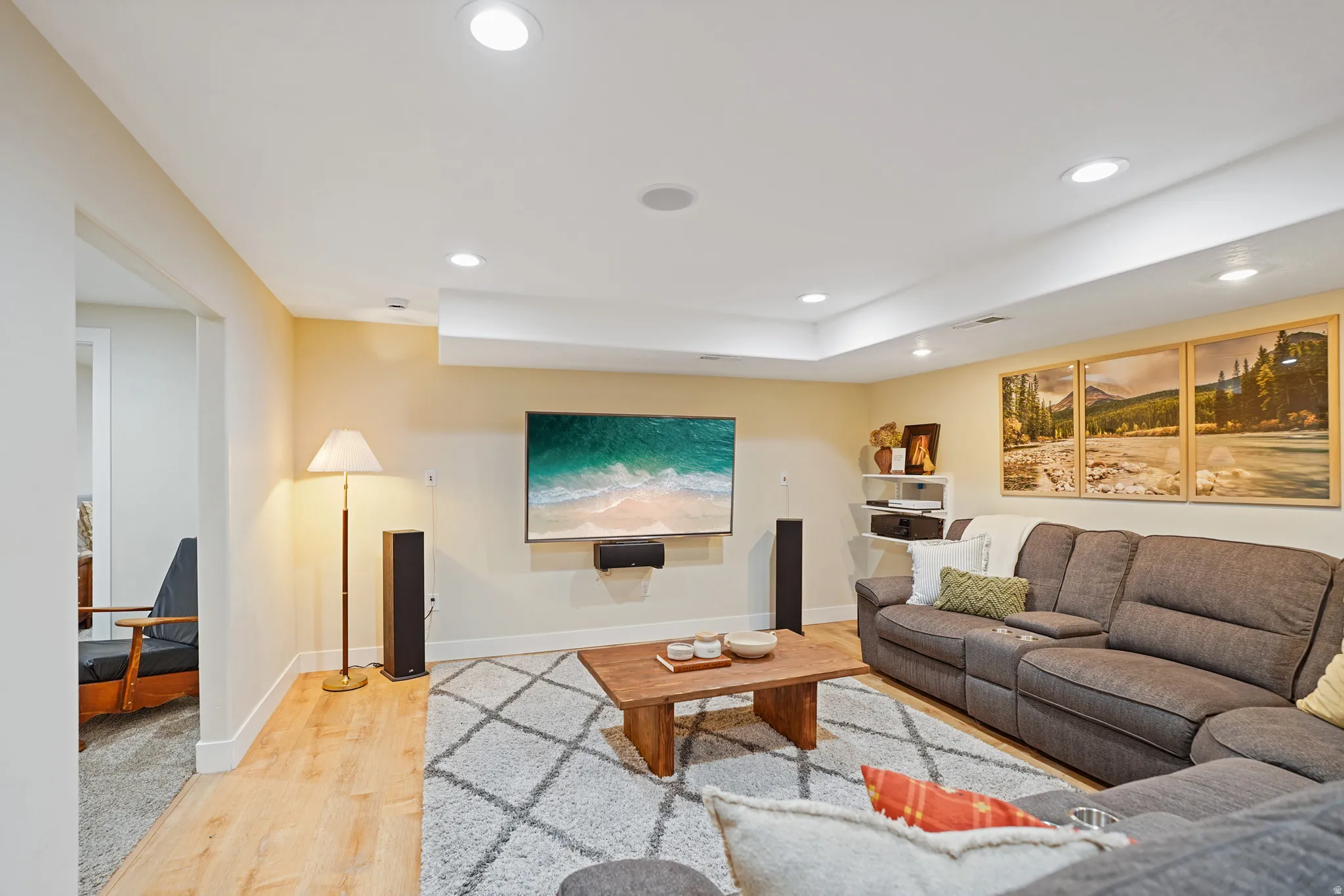 Living room with light wood-type flooring and recessed lighting