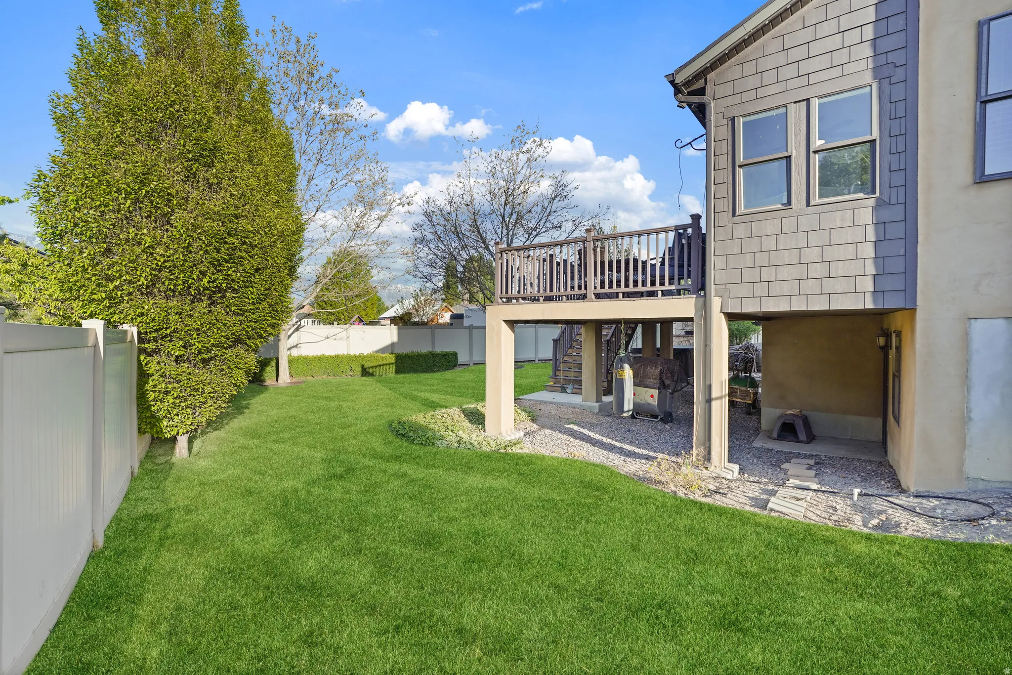 Fenced backyard featuring a wooden deck and stairs