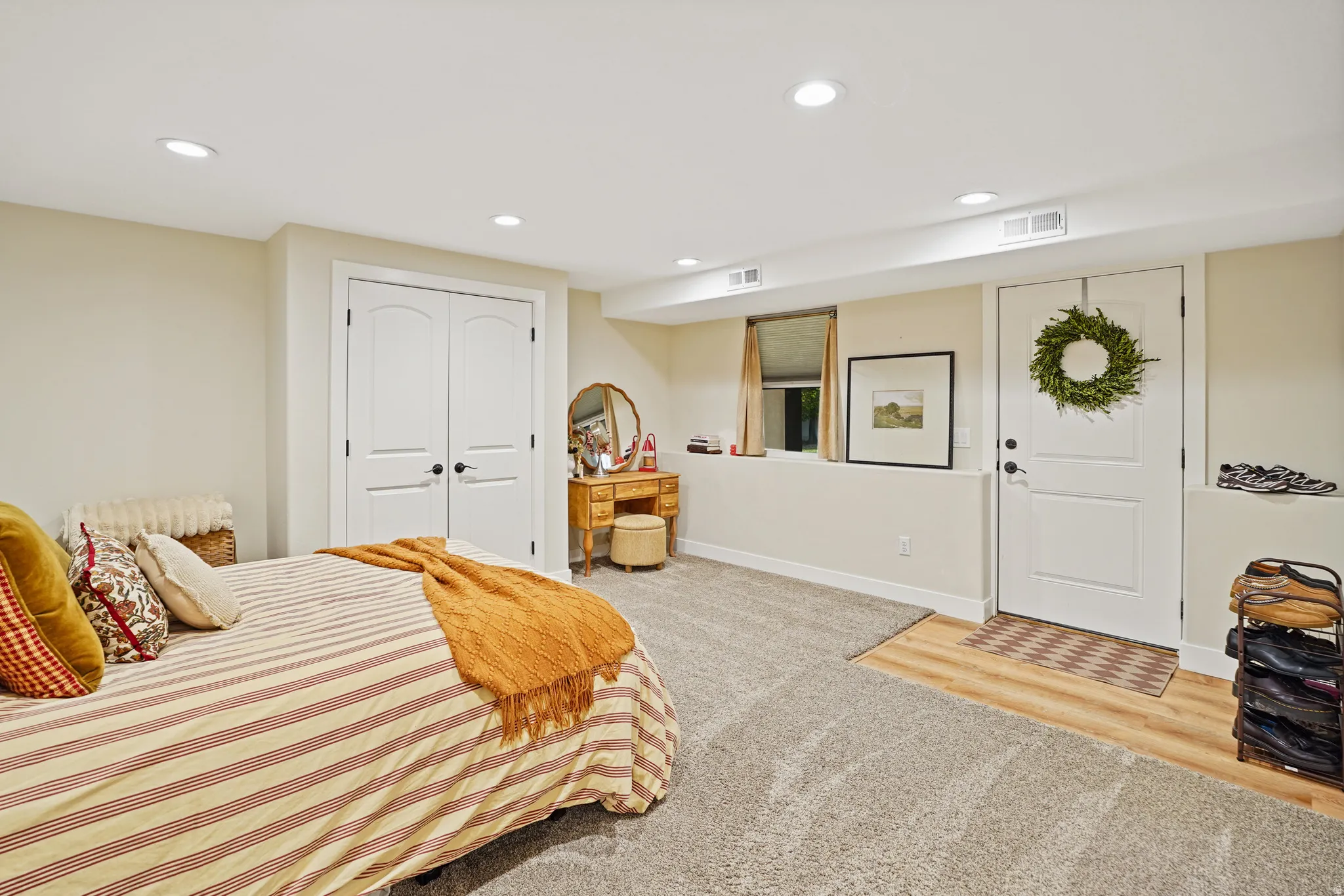Bedroom with recessed lighting, a closet, light carpet, and light wood finished floors
