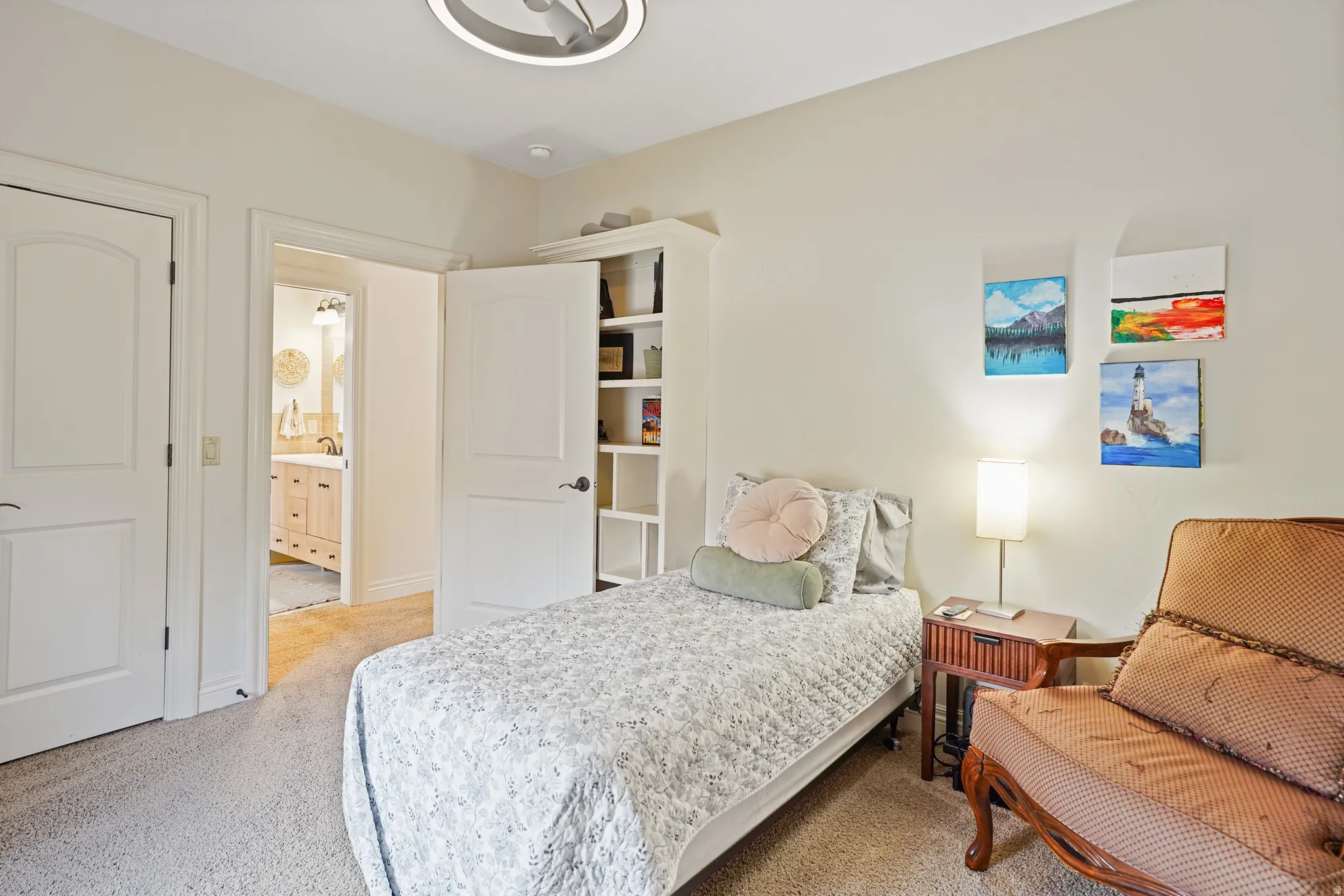 Bedroom featuring a closet, light colored carpet, and ensuite bathroom