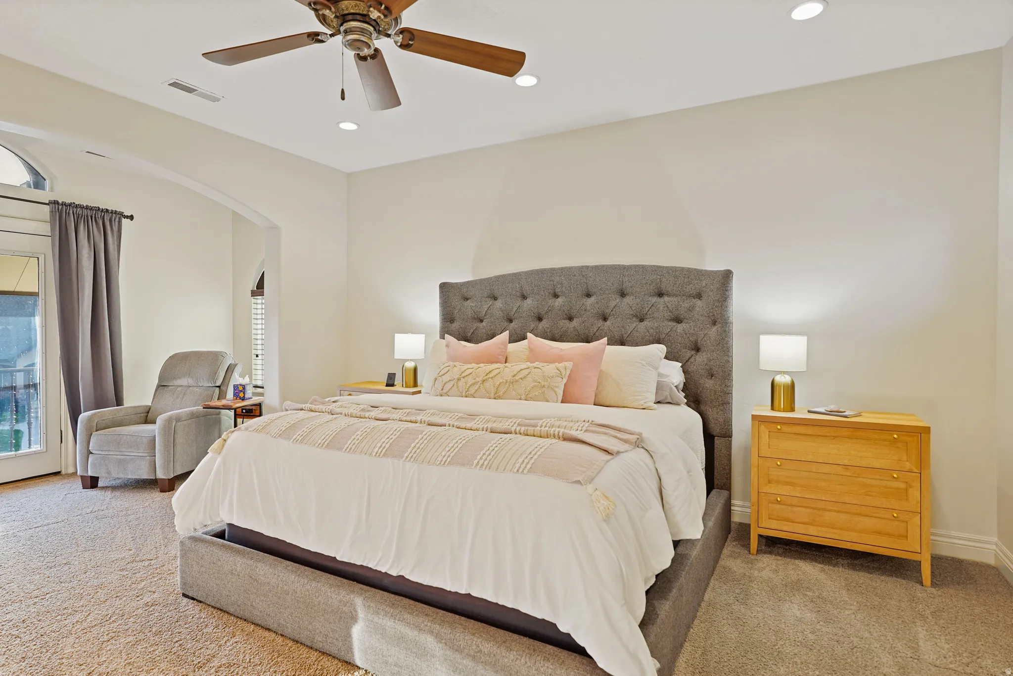 Primary bedroom with carpet flooring, recessed lighting, balcony and sitting area,