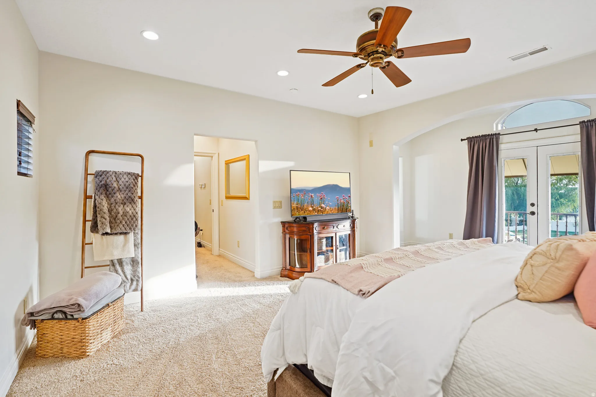 Primary bedroom with carpeted bedroom with french doors, arched walkways, access to exterior, recessed lighting, and ceiling fan