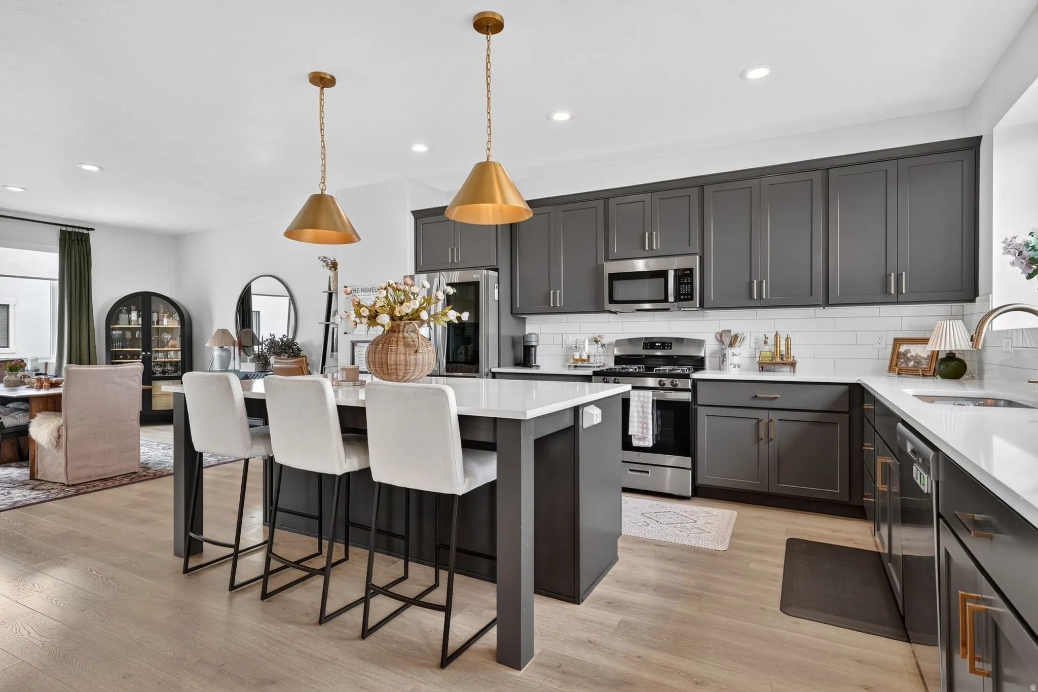 Kitchen featuring stainless steel appliances, a center island, a breakfast bar area, light wood-style flooring, and pendant lighting