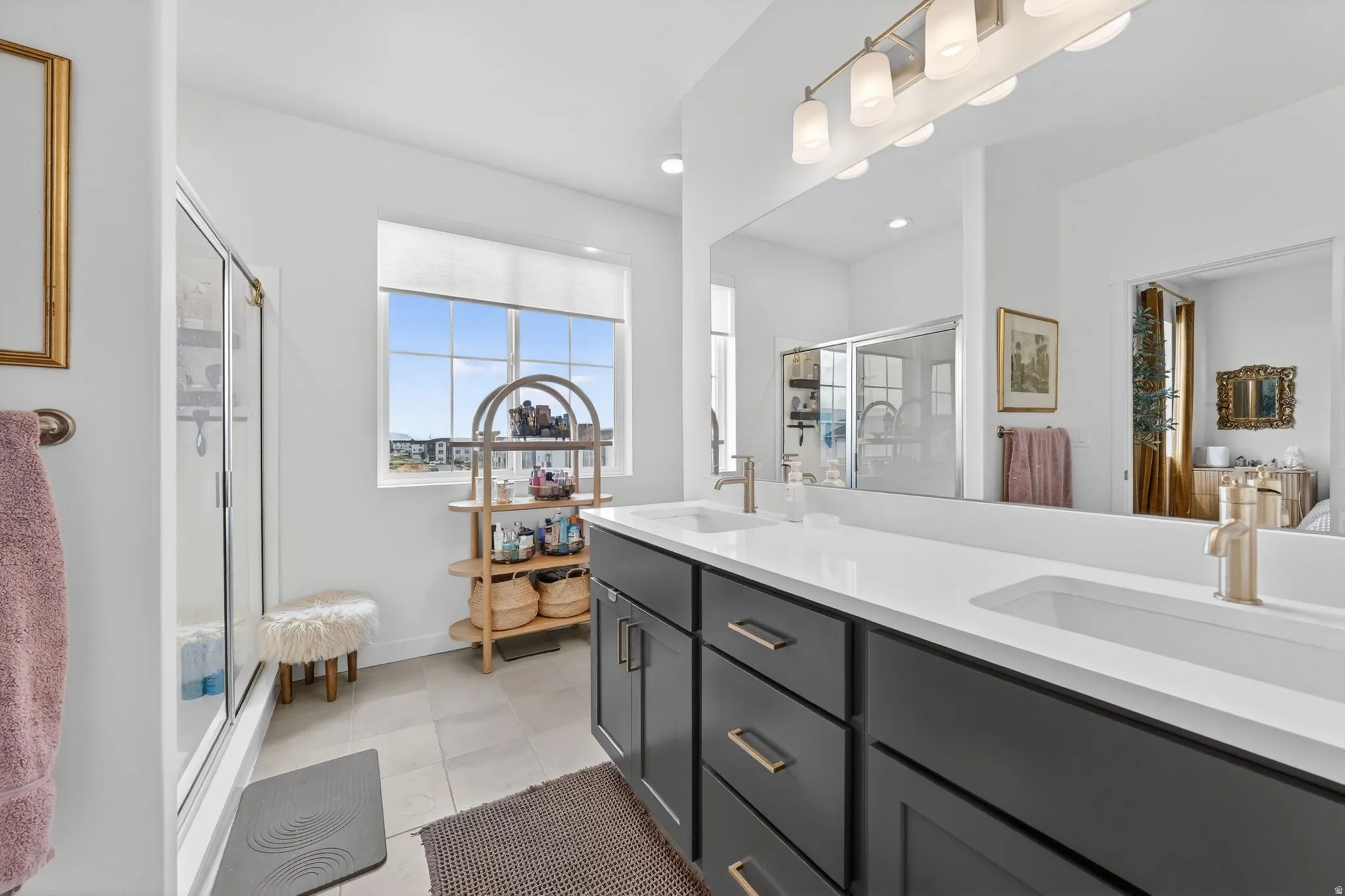 Bathroom featuring a shower stall, double vanity, light tile patterned floors, and recessed lighting