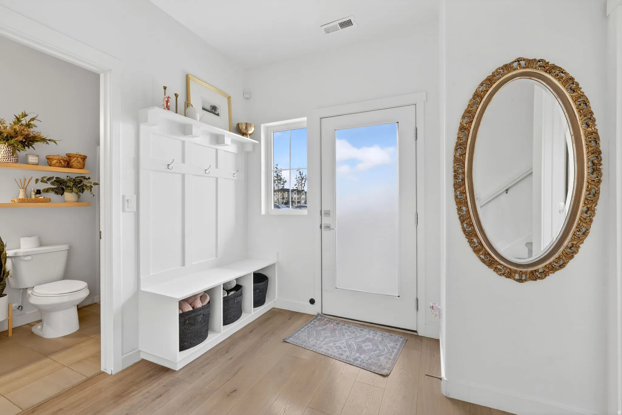 Mudroom with light wood finished floors and baseboards