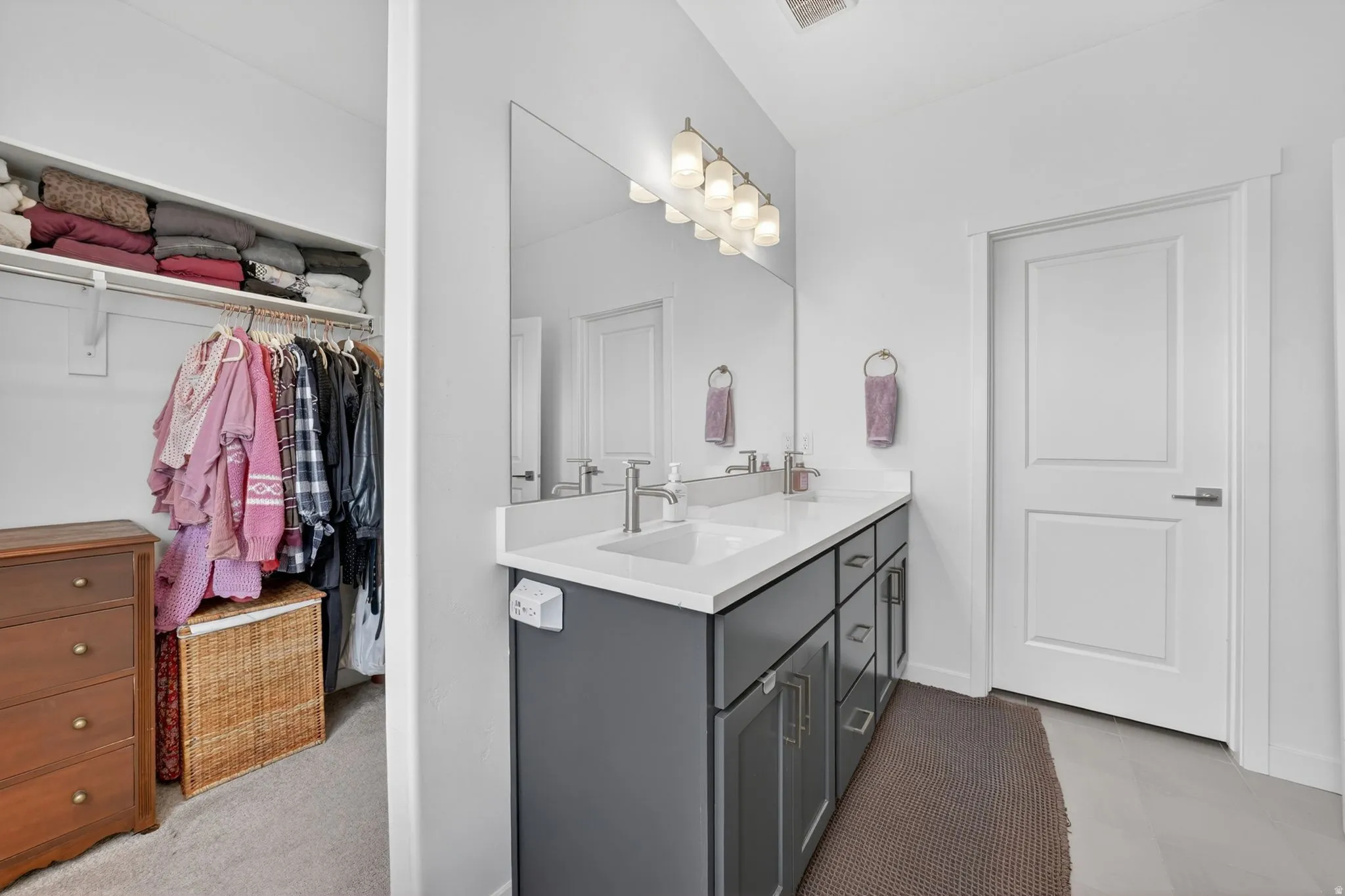 Full bathroom featuring a walk in closet and double vanity