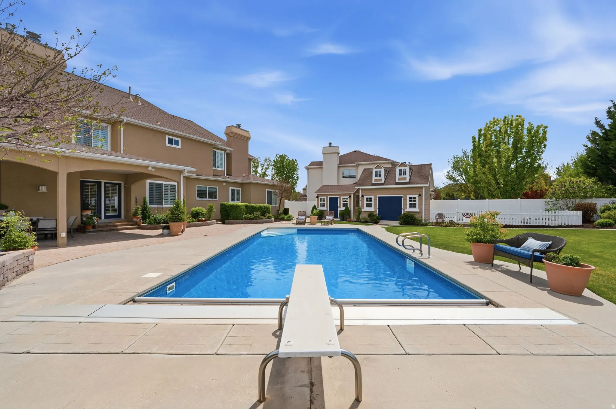 View of pool featuring patio surround and a diving board
