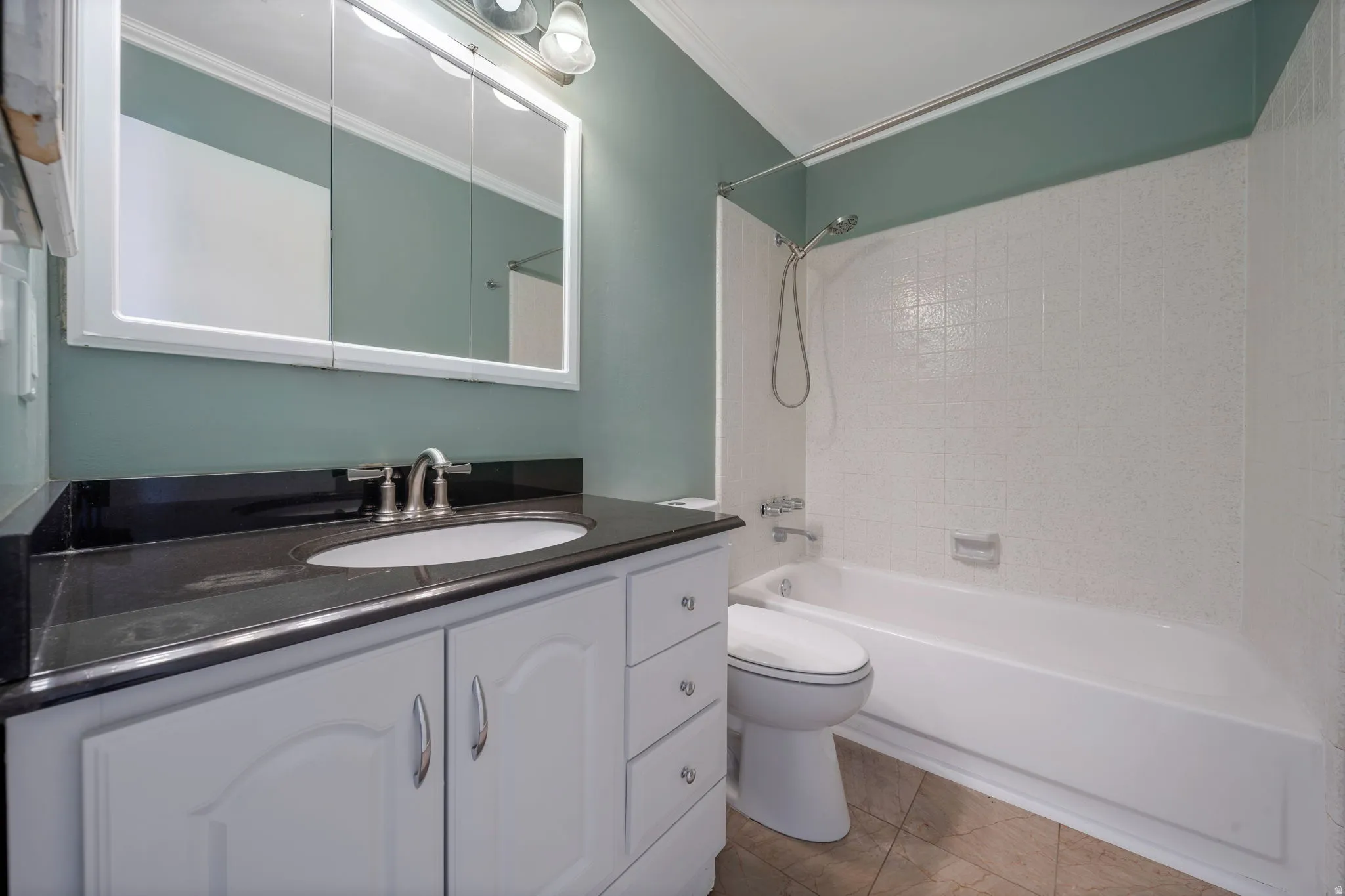 Bathroom featuring vanity, shower / washtub combination, and ornamental molding