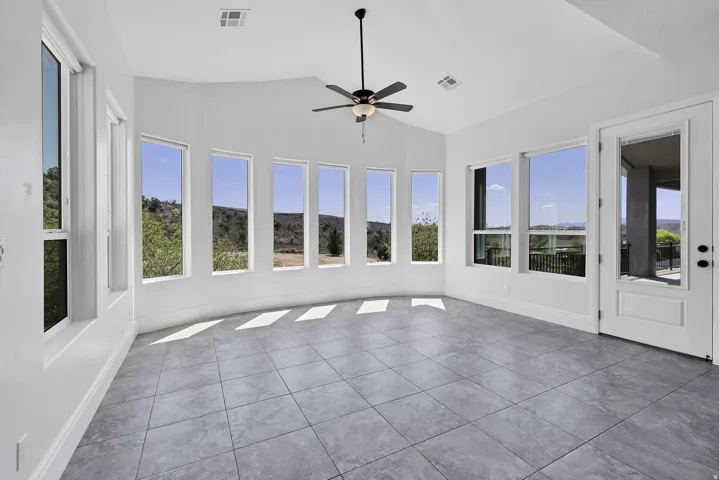 Unfurnished sunroom with lofted ceiling, tile patterned flooring, and healthy amount of natural light