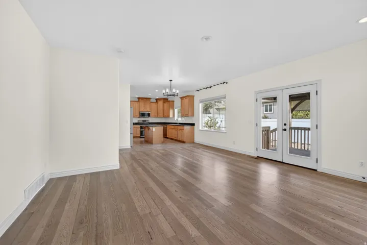 Expansive main living area with wood-finish flooring, recessed lighting, and crisp white baseboards