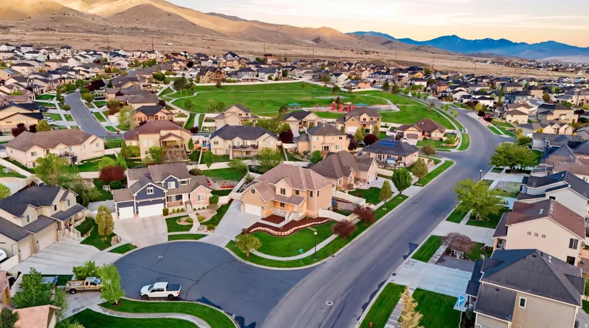 Aerial view of property and surrounding area with a mountain backdrop and nearby suburban area