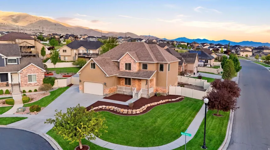 Traditional-style home featuring stone siding, stucco siding, driveway, a shingled roof, and a residential view