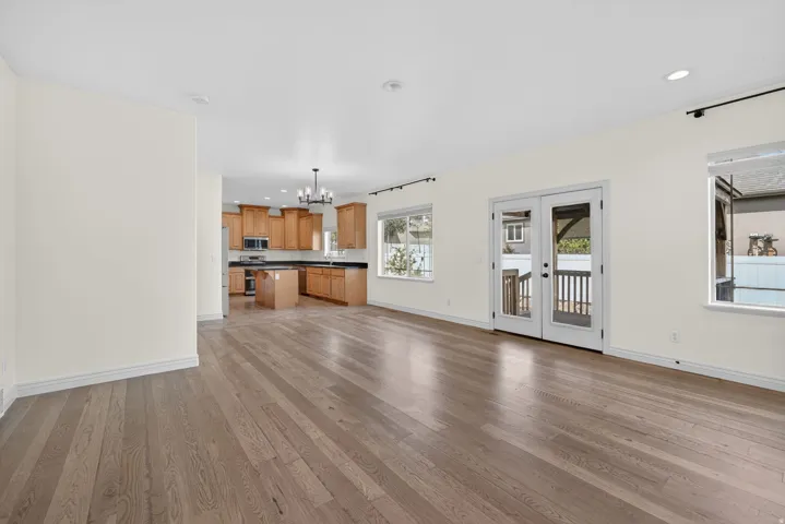 Wood-finish flooring throughout, featuring a kitchen with wood cabinetry and dark countertops