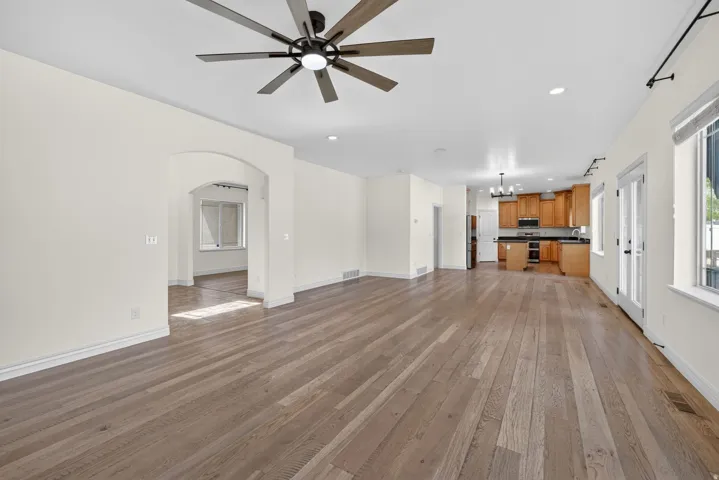Expansive living area featuring wide plank wood-finish flooring, recessed lighting, and a contemporary ceiling fan