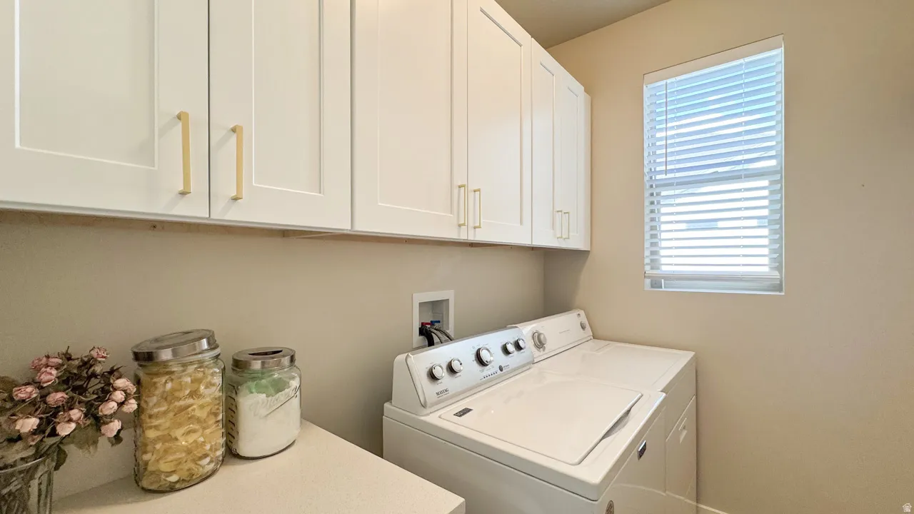 Laundry area featuring separate washer and dryer and cabinet space