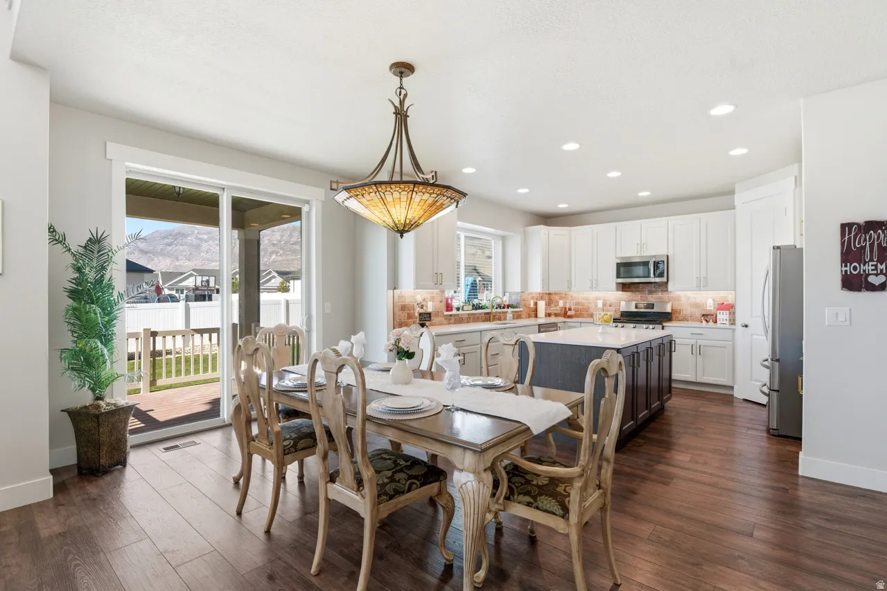 Dining area with dark wood-style flooring, recessed lighting, and a mountain view